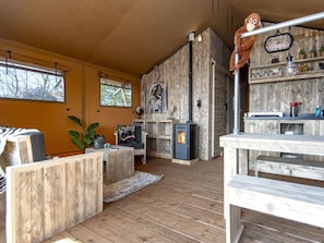 Een knusse woonkamer met een open haard, houten meubels en een pluchen apenbeeld aan de muur.