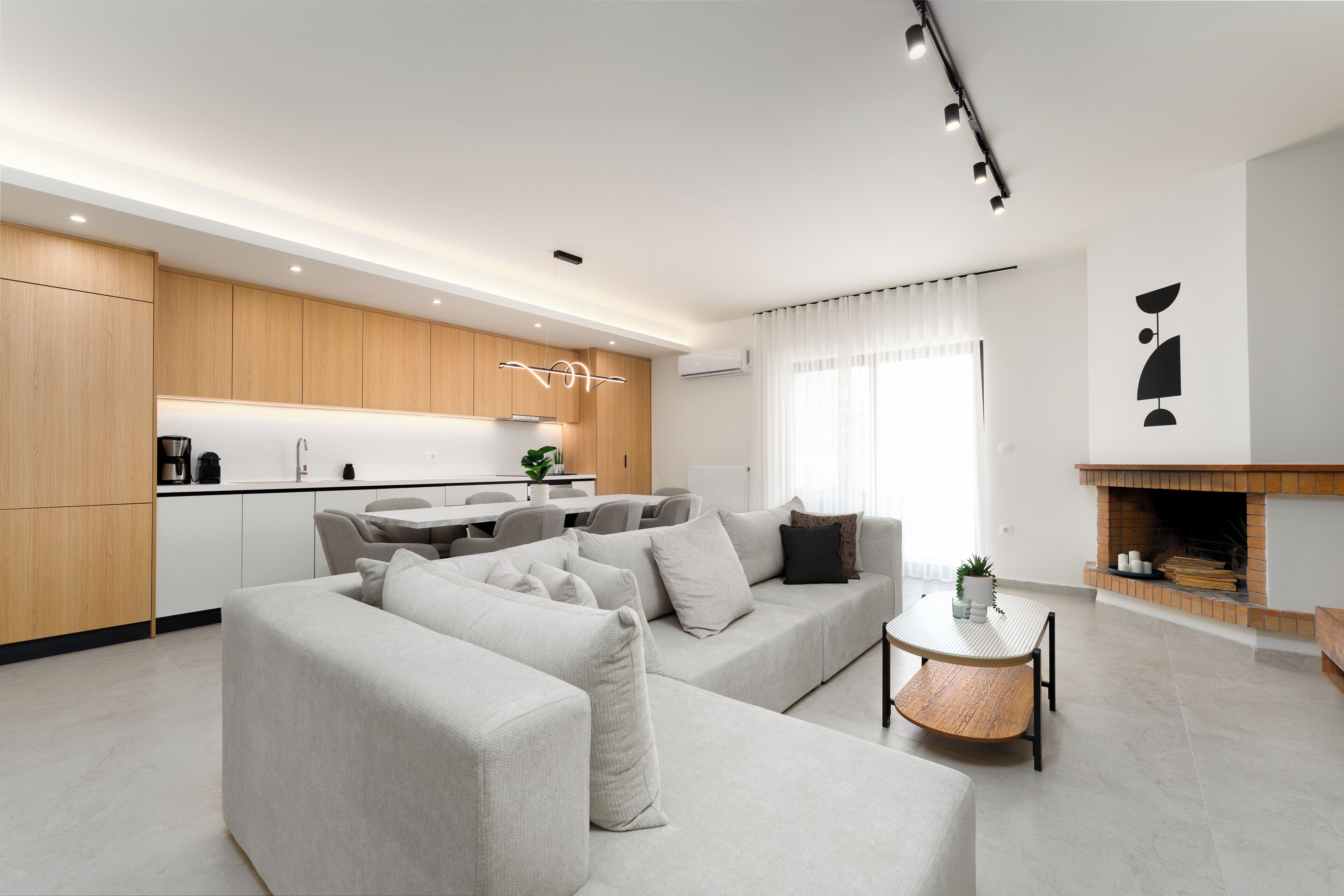 A modern living room with a sofa, a coffee table, and a fireplace.