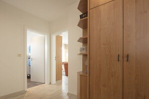 A hallway with wooden cabinets and a door leading to a room with a radiator. - Holiday apartment in Norderney with Wi-Fi (Norderney)