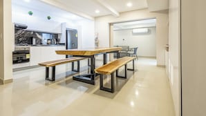 Eine moderne Küche mit Marmorarbeitsplatte, eingebautem Backofen und einem Essbereich mit Holztisch und Bänken.