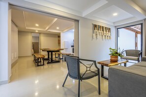 A modern living room with a dining area, a sofa, a chair, and a table. - Cartagena Luxury House (Cartagena de Indias)