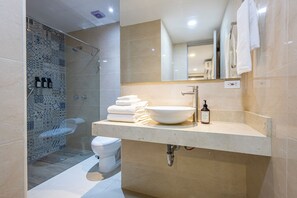 Une salle de bain moderne avec un grand lavabo, des toilettes et un espace douche.