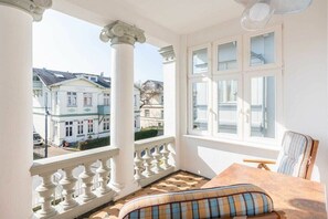 Un balcone con vista su edifici, un tavolo con un cuscino e una sedia.