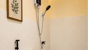 Un baño con inodoro, ducha y una planta en una maceta colgada en la pared.