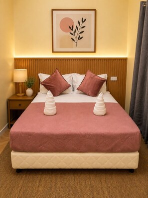 A hotel room with a bed, a nightstand with a lamp, a framed artwork on the wall, and a window with curtains. - RV3 Transient House (Angeles)