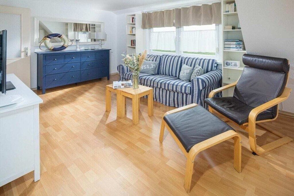A living room with a sofa, a chair, a coffee table, and a television.