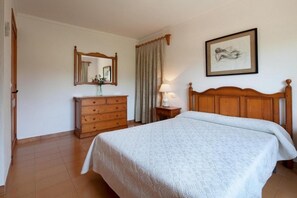 A bedroom with a wooden bed, a dresser, a mirror, a lamp, and a framed picture on the wall. - Picturesque Country Villa for 6 (Pollença)