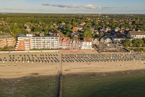 Eine Küstenstadt mit Strand, Wohnhäusern und einem Steg.