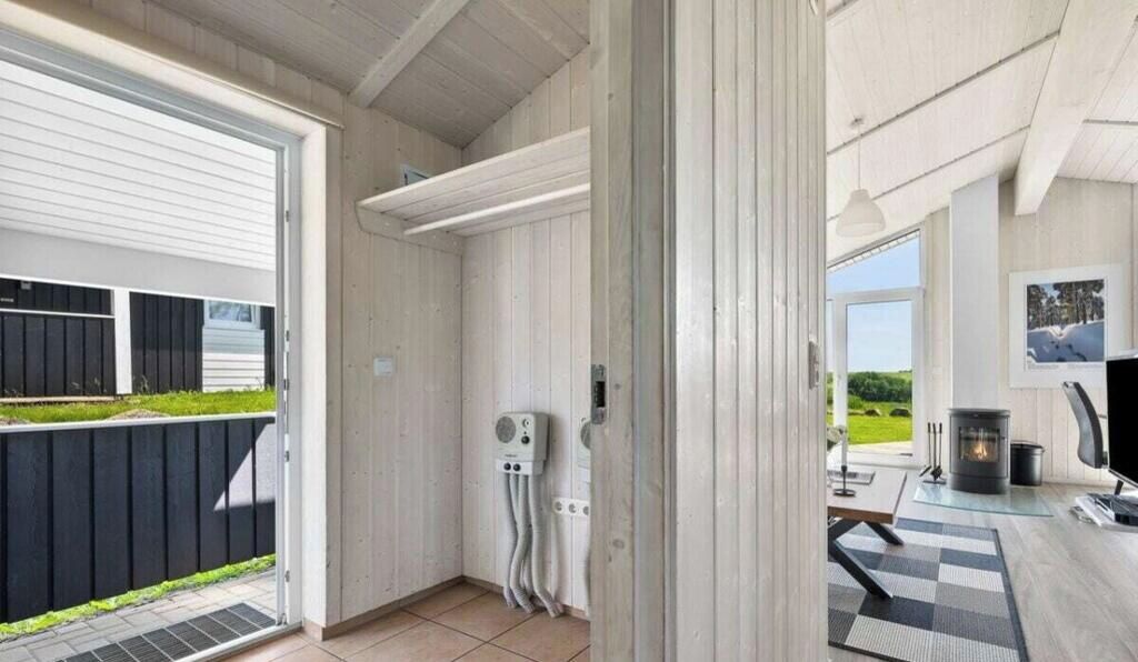 A room with a fireplace, a window, and a door leading outside.