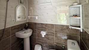 A bathroom with a wooden ceiling, a sink, a toilet, and a shower. - Natural Pansiyon (KUMLUCA)