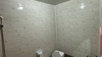 Un baño con inodoro, lavamanos y ducha.