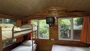 L’intérieur d’une cabine est aménagé avec des lits superposés, un téléviseur et des fenêtres équipées de rideaux.