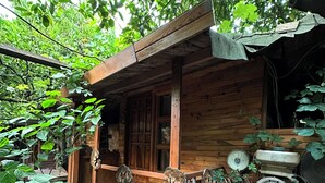 A rustic wooden cabin with a bicycle parked in front. - Natural Pansiyon (KUMLUCA)