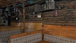 A rustic cabin interior with wooden walls, a patterned rug, and a wooden table.