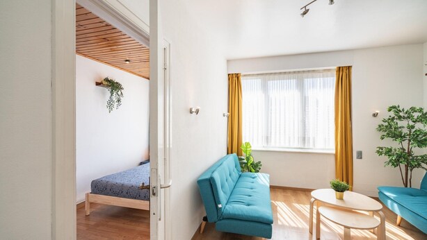 Un soggiorno moderno con un divano, un tavolino e un letto.