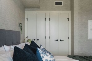 A bedroom with a bed, a wardrobe, and a wall-mounted plant. - The Southwest Pottery Suite | DT Kelowna 1BR | Pool&Sauna (Kelowna)