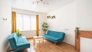 Una sala de estar con sofá, una mesa de centro y una planta.
