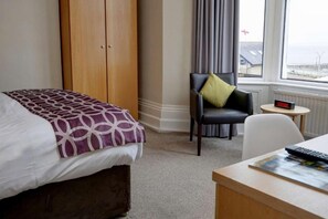 A hotel room with a bed, a chair, a desk, and a window. - Lothersdale Hotel by Belvilla - Standard Single Room (Lancaster)
