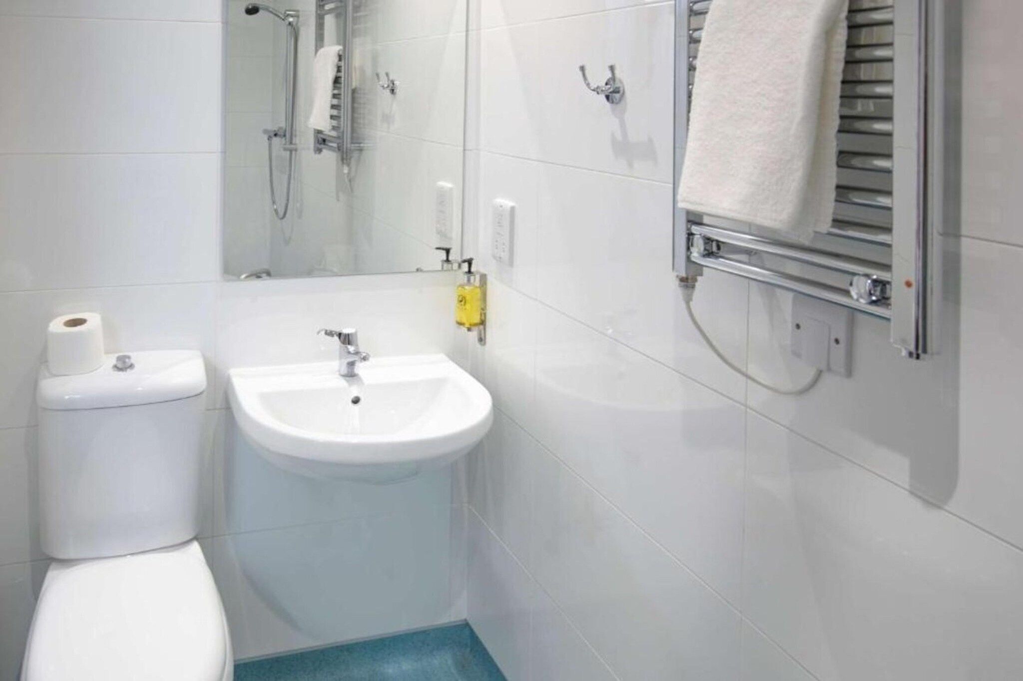 A bathroom with a toilet, sink, and shower.