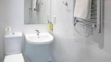 A bathroom with a toilet, sink, and shower.