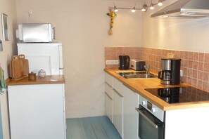 A compact kitchen with a microwave, coffee maker, and a small oven. - Holiday home with 1 bedroom (Nebelschütz OT Dürrwicknitz)