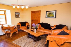 A living room with a sofa set, a wooden coffee table, and a wooden door. - Grethe Ground Floor || Rockow (Rockow)