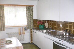 A kitchen with white cabinets, a stainless steel sink, and a stove. - Holiday apartment with 2 bedrooms (Hofstetten)