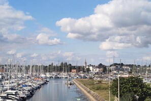 A marina with numerous boats docked along the water's edge, a clear sky, and a distant building. - Lovely Holiday Home in Sarzeau for 8 (Sarzeau)
