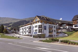 Ein mehrstöckiges Hotel mit Restaurant und Küche, eingebettet in eine gebirgige Landschaft.