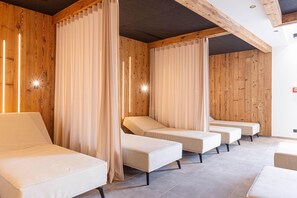 Una sala de spa amb panells de fusta, filera de camells d'massatge i il·luminació ambiental.