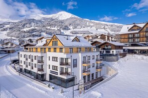 Un hotel amb diverses plantes, balcons i un senyal que indica que forma part d'Alps Resorts.