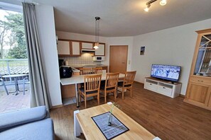 A compact living space with a kitchenette, dining area, and a television. - House by the spa park (Ahlbeck (Seebad))