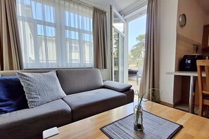 A modern living room with a sofa, a coffee table, and a view of the outdoors. - House by the spa park (Ahlbeck (Seebad))