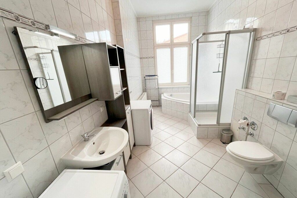Un bagno moderno con lavandino, WC e zona doccia.