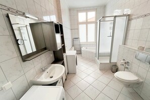 A modern bathroom with a sink, toilet, and shower area. - Holiday apartment Bülowstraße (Heringsdorf (Seebad))