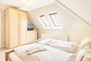 A bedroom with two beds, a wardrobe, a radiator, and skylights. - Holiday apartment with 1 bedroom (Ahlbeck (Seebad))