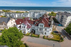 Ett bostadsområde vid kusten med en framträdande vit byggnad som har ett rött tegeltak och som omges av andra liknande byggnader.