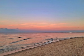 Ein Strand mit ruhiger See und blauem Himmel.