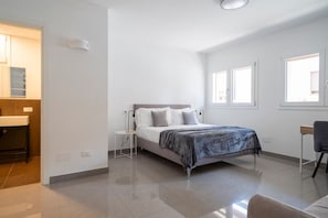 A bedroom with a bed, bedside table, and a desk with a chair. - Marghera Smart Stay 2 | A Comfortable Room in Venice (Marghera)