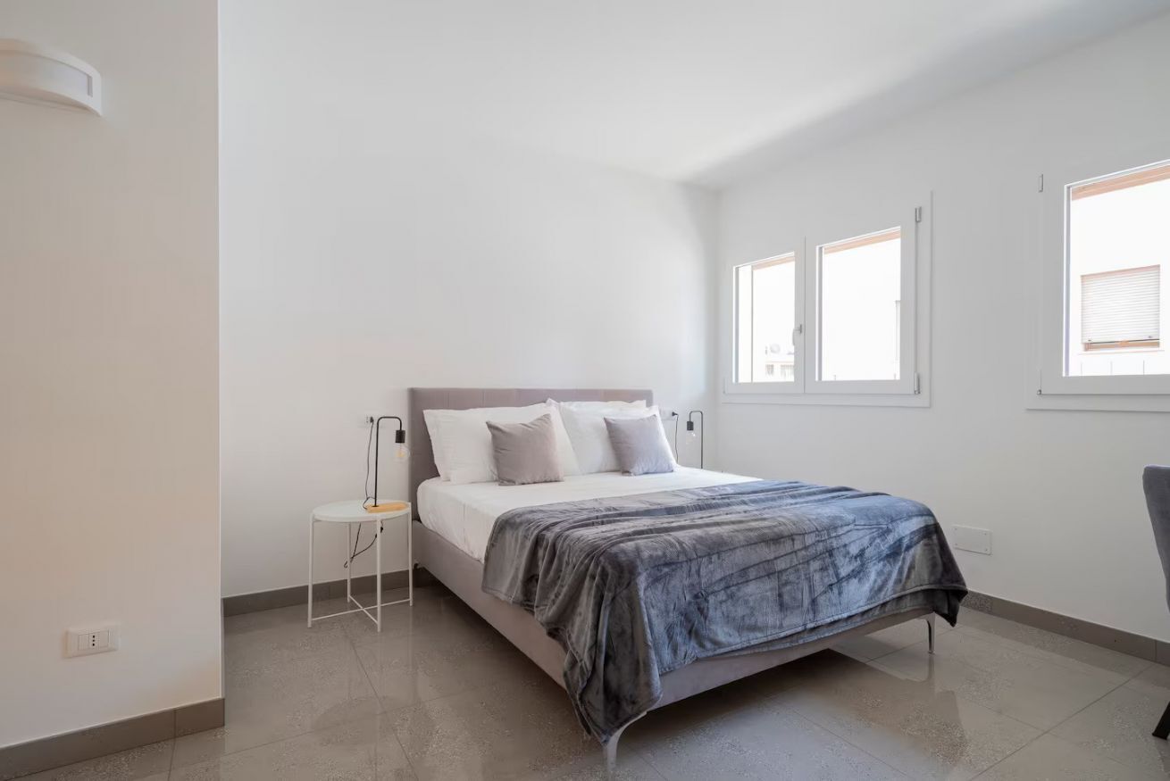 Una camera da letto con un letto, un comodino e una finestra.
