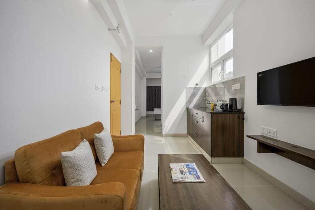 A modern living room with a sofa, coffee table, and a TV mounted on the wall.