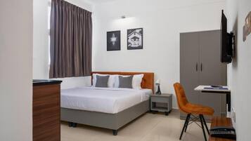 Una camera da letto con un letto, una scrivania, una sedia, un armadio e due quadri appesi al muro.