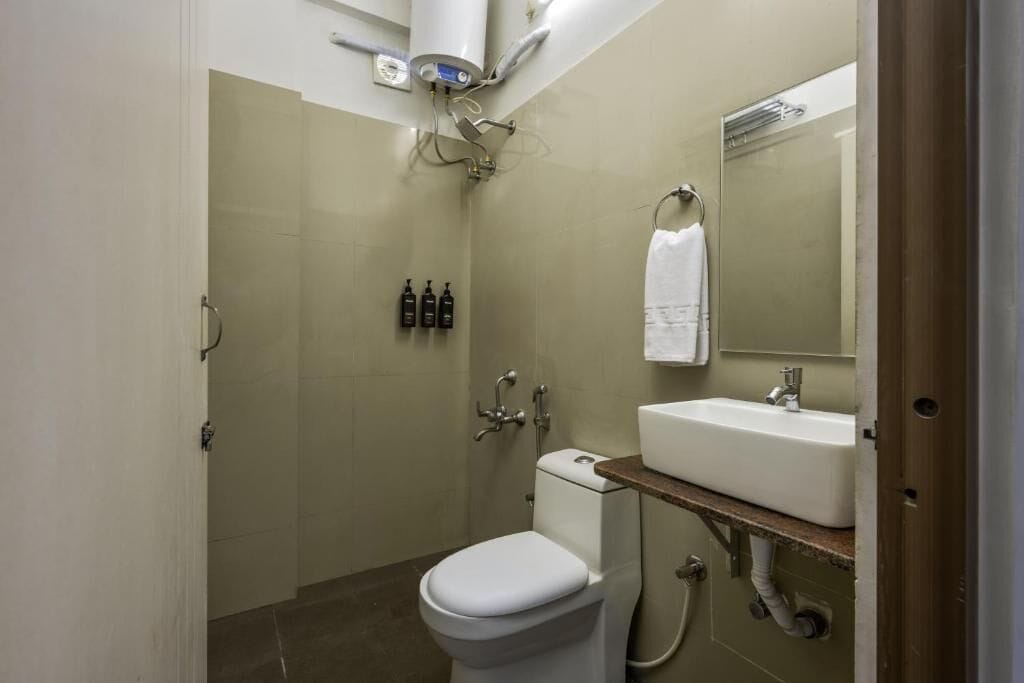 Ein Badezimmer mit Toilette, Waschbecken, Spiegel und Dusche.