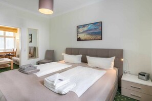 Ein Hotelzimmer mit zwei Betten, einer Sitzecke mit Tisch und einem Bild an der Wand.