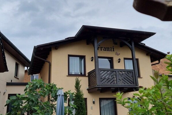 Un edificio con un balcone e un cartello che riporta la scritta 'Franzi's'.