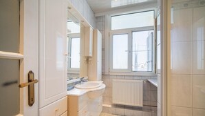 Un bagno con lavandino, specchio e finestra.