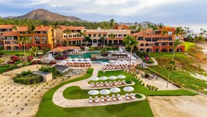 A resort with a central pool, multiple lounge areas, and a mountain backdrop. - Zoëtry Casa Del Mar Los Cabos One Bedroom Suite Ocean View (San José del Cabo)