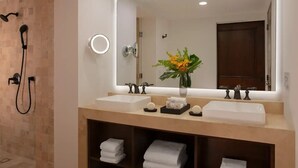 A bathroom with two sinks, a large mirror, a shower, and a vase with flowers. - Zoëtry Casa Del Mar Los Cabos One Bedroom Suite Ocean View (San José del Cabo)