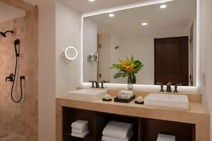 A bathroom with two sinks, a large mirror, a shower, and a vase with flowers. - Zoëtry Casa Del Mar Los Cabos One Bedroom Suite Ocean View (San José del Cabo)