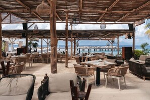 An outdoor seating area with wicker furniture and a view of the ocean. - 1BR LUX Beachfront Stay | ONE Mambo 14 by Bocobay (Willemstad)